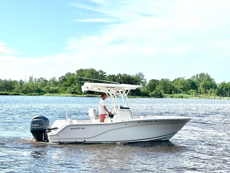 Slide: The Image of 2020 Sea Fox 228 Commander boat cruising on a calm river with lush green shoreline. - 4