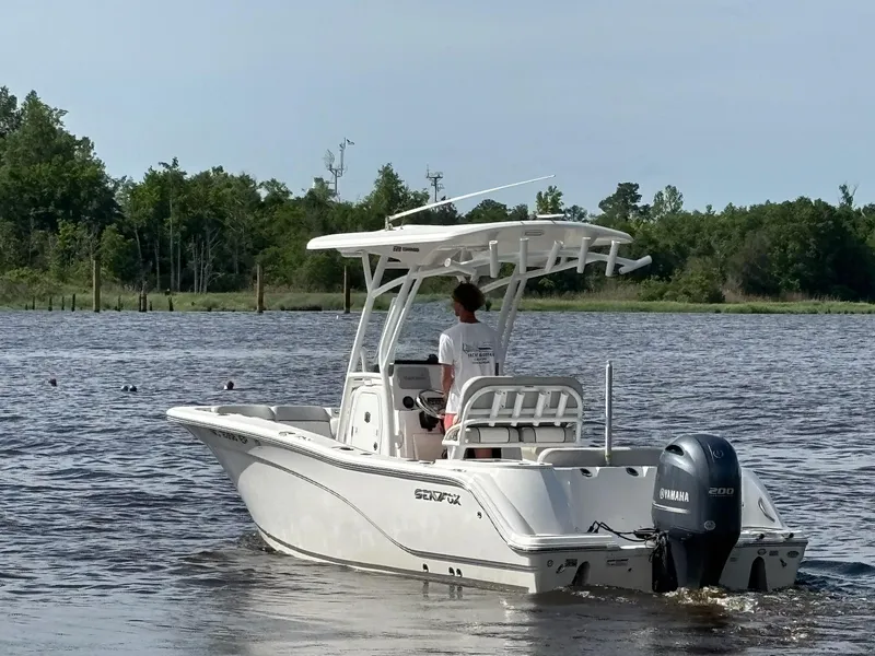 Slide: The Image of 2020 Sea Fox 228 Commander boat cruising on a calm river with lush green trees. - 5