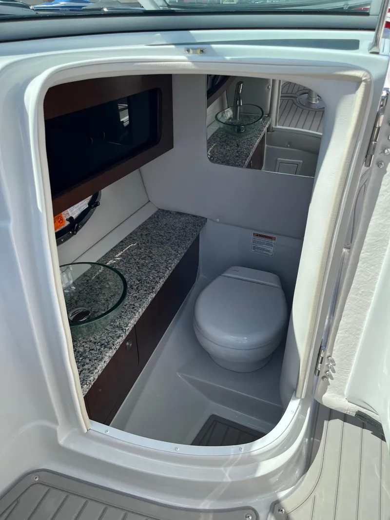 Slide: The Image of 2026 Crownline 298 SS boat bathroom with modern fixtures and granite countertop. - 13