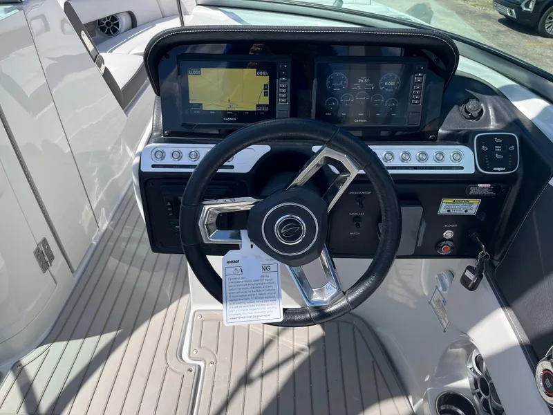 Slide: The Image of 2026 Crownline 298 SS boat dashboard with steering wheel and navigation displays. - 15