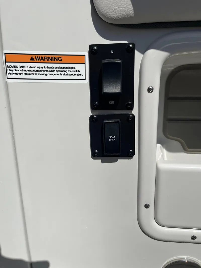 Slide: The Image of 2026 Crownline 298 SS boat control panel with warning label and switches. - 17