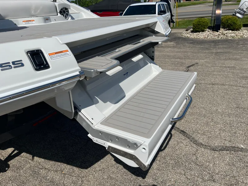 Slide: The Image of 2026 Crownline 298 SS boat with extended swim platform in a parking lot. - 21