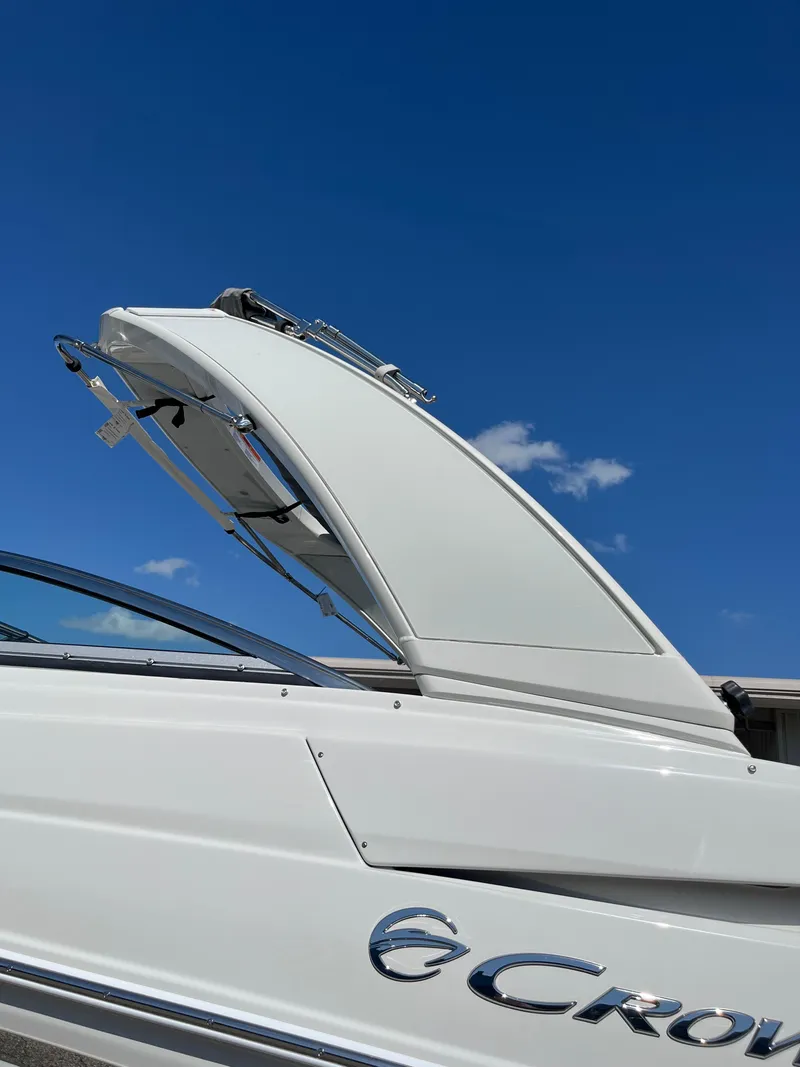 Slide: The Image of 2026 Crownline 298 SS boat against clear blue sky. - 23