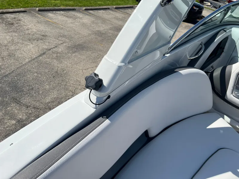 Slide: The Image of 2026 Crownline 298 SS boat interior with white seating and open hatch. - 24