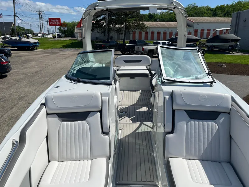 Slide: The Image of 2026 Crownline 298 SS boat with white seating and open deck, parked outdoors. - 4
