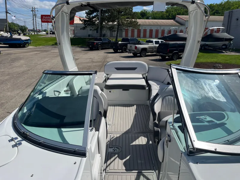 Slide: The Image of 2026 Crownline 298 SS boat interior with open seating and windshield, parked outdoors. - 5