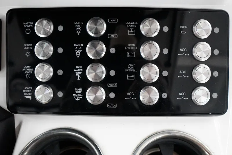 Slide: The Image of Control panel of a 2020 Caymas 26 HB boat with various switches and dials. - 19