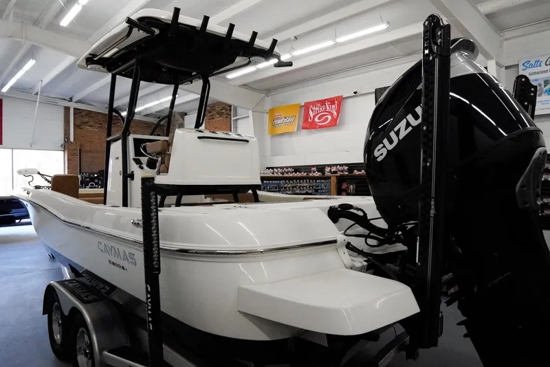 Slide: The Image of 2020 Caymas 26 HB boat with Suzuki engine in showroom setting. - 2