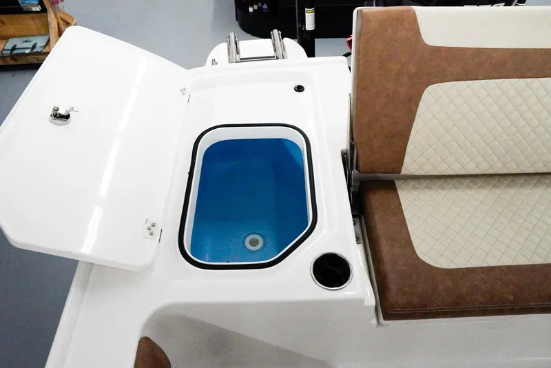 Slide: The Image of 2020 Caymas 26 HB boat interior with open storage compartment and cushioned seating. - 25
