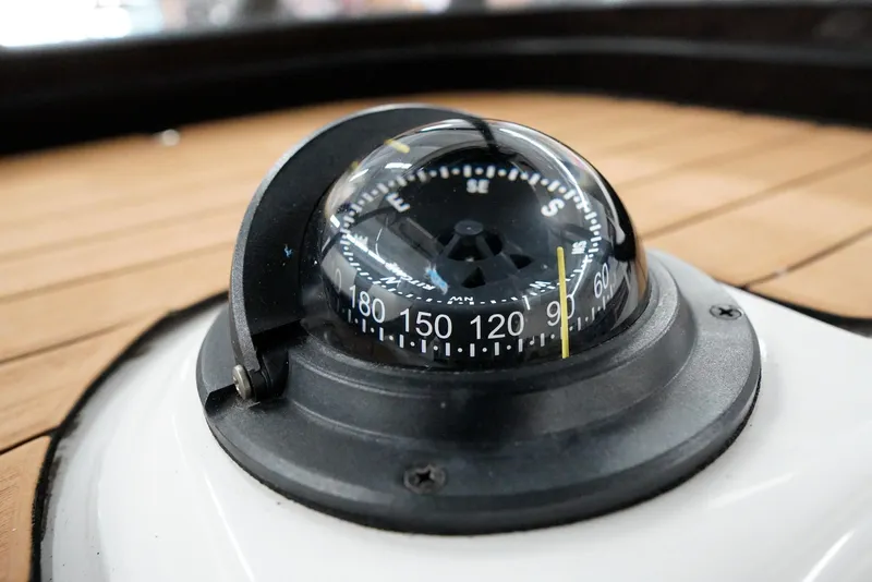 Slide: The Image of Compass on 2020 Caymas 26 HB boat, wooden deck background. - 29