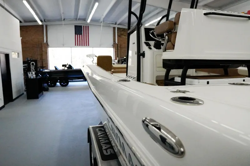 Slide: The Image of 2020 Caymas 26 HB boat displayed in showroom with American flag. - 4