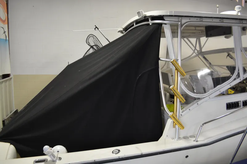 Slide: The Image of 2004 Carolina Classic 28 boat with black cover and fishing rod holders. - 16