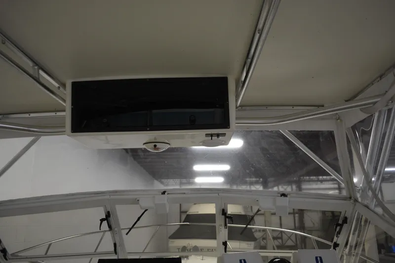 Slide: The Image of Interior view of a 2004 Carolina Classic 28 boat, showcasing the helm area and overhead compartment. - 19