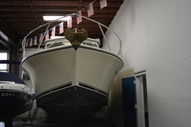 Slide: The Image of 2004 Carolina Classic 28 boat in indoor storage with American flags above. - 2