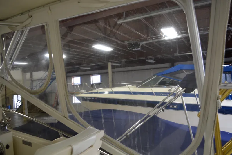 Slide: The Image of 2004 Carolina Classic 28 boat in indoor storage, viewed through a window. - 21