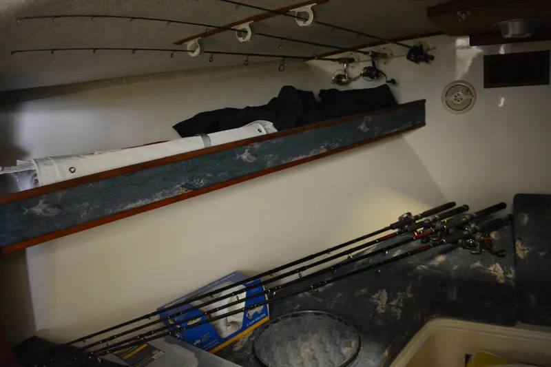 Slide: The Image of 2004 Carolina Classic 28 interior with fishing rods and storage area. - 31