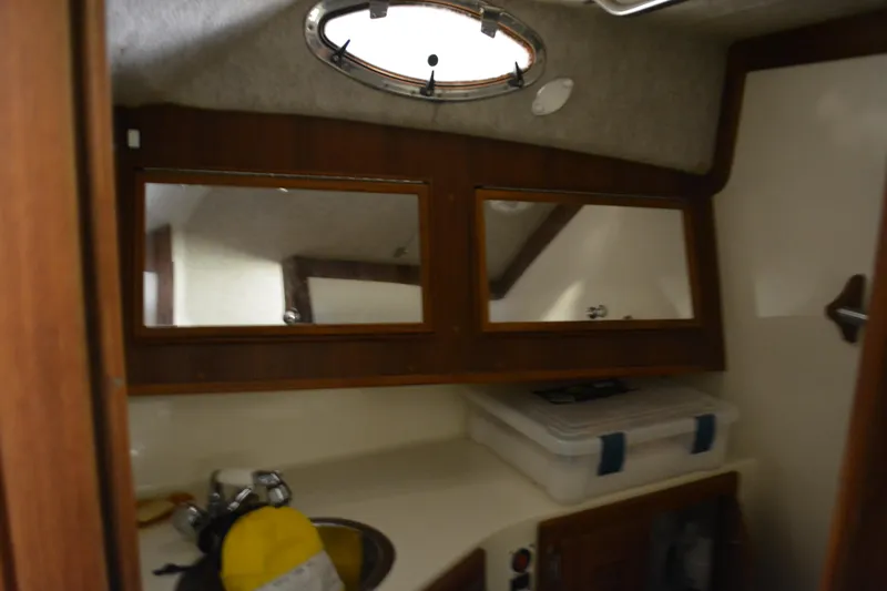 Slide: The Image of 2004 Carolina Classic 28 boat interior with mirrors and storage area. - 32