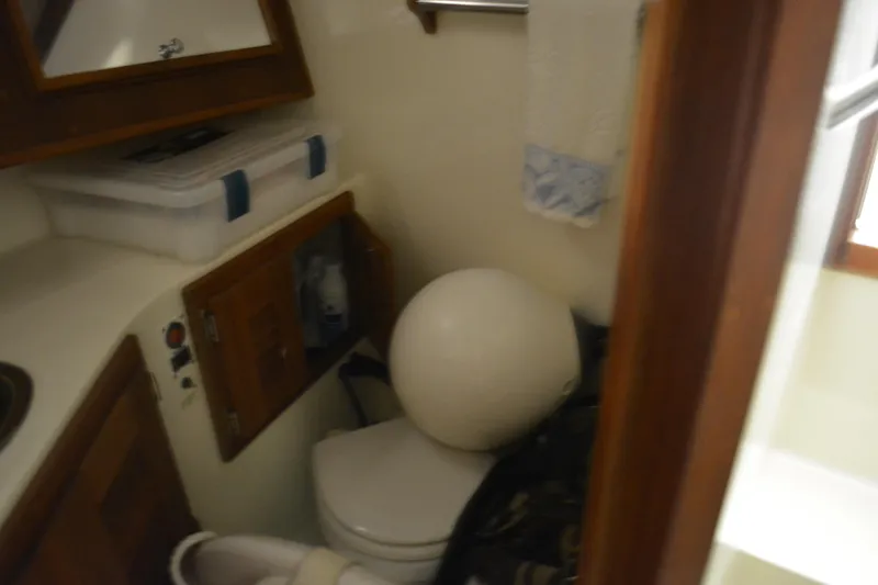 Slide: The Image of 2004 Carolina Classic 28 boat interior with compact bathroom and storage. - 33