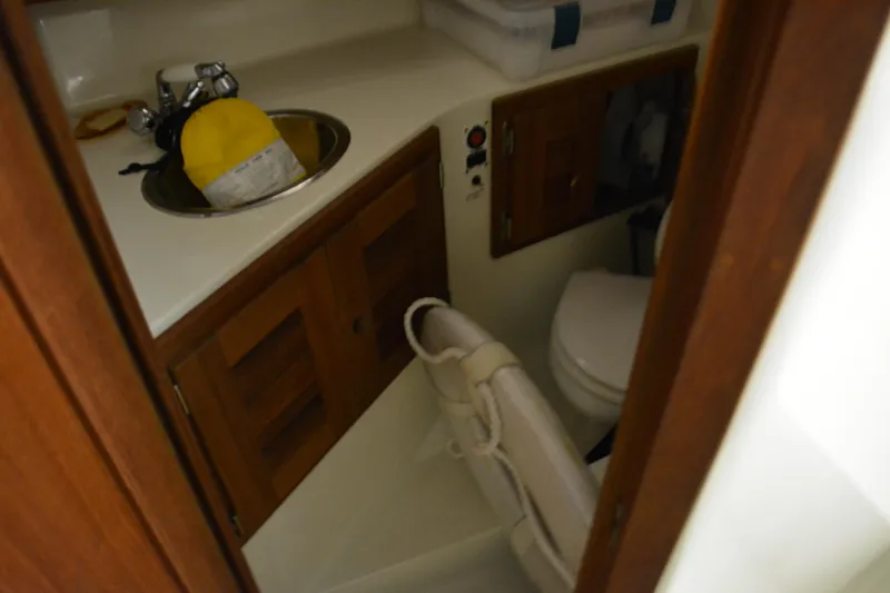 Slide: The Image of 2004 Carolina Classic 28 boat interior with sink, storage, and toilet. - 34