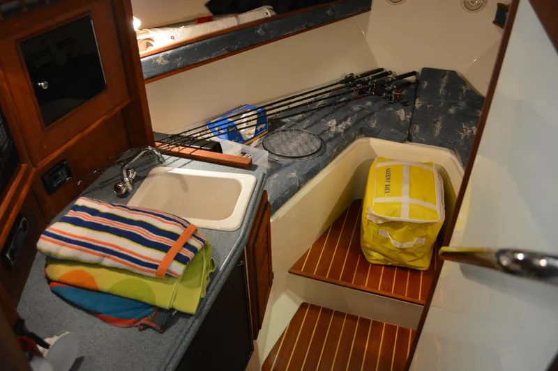 Slide: The Image of Interior of 2004 Carolina Classic 28 boat with sink, fishing rods, and striped towels. - 38