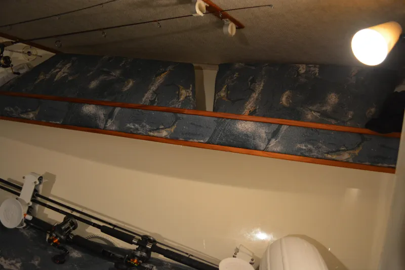 Slide: The Image of 2004 Carolina Classic 28 interior with fishing rods and cushioned storage. - 39