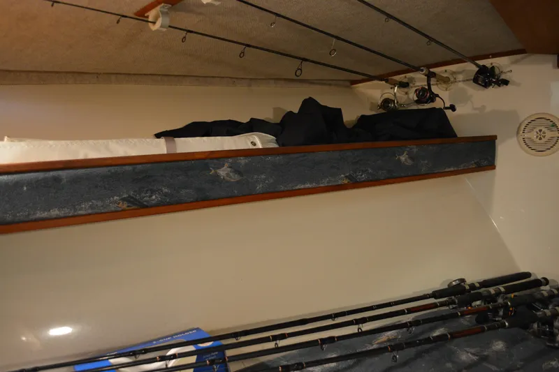 Slide: The Image of Interior of 2004 Carolina Classic 28 boat with fishing rods and storage shelf. - 41