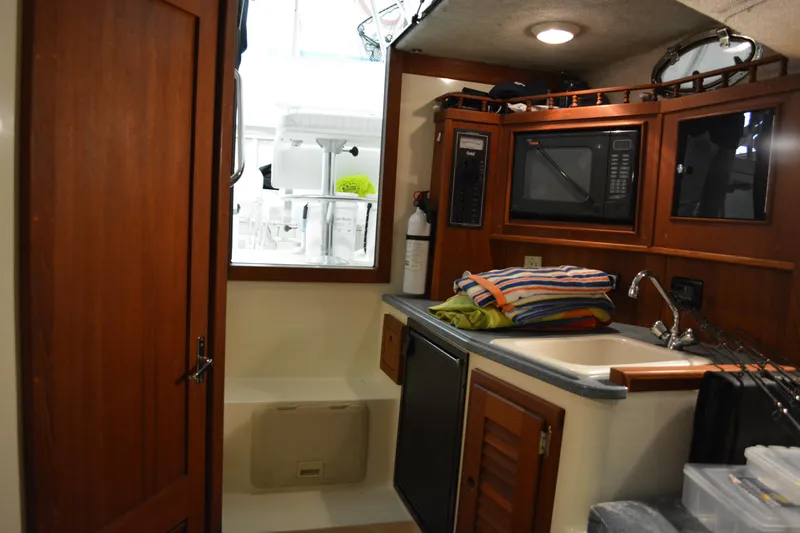 Slide: The Image of 2004 Carolina Classic 28 interior with kitchenette, microwave, and storage. - 44