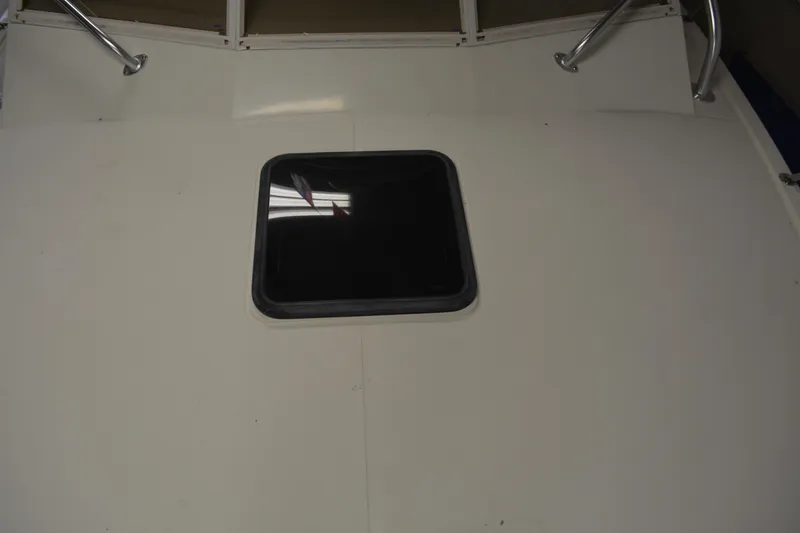 Slide: The Image of 2004 Carolina Classic 28 boat deck with a central hatch and metal railings. - 5