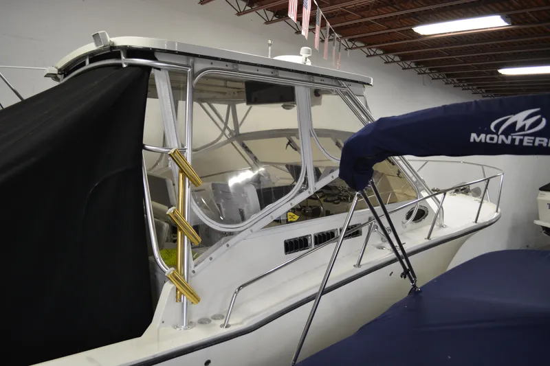 Slide: The Image of 2004 Carolina Classic 28 boat in indoor storage, partially covered, with visible cockpit and equipment. - 7