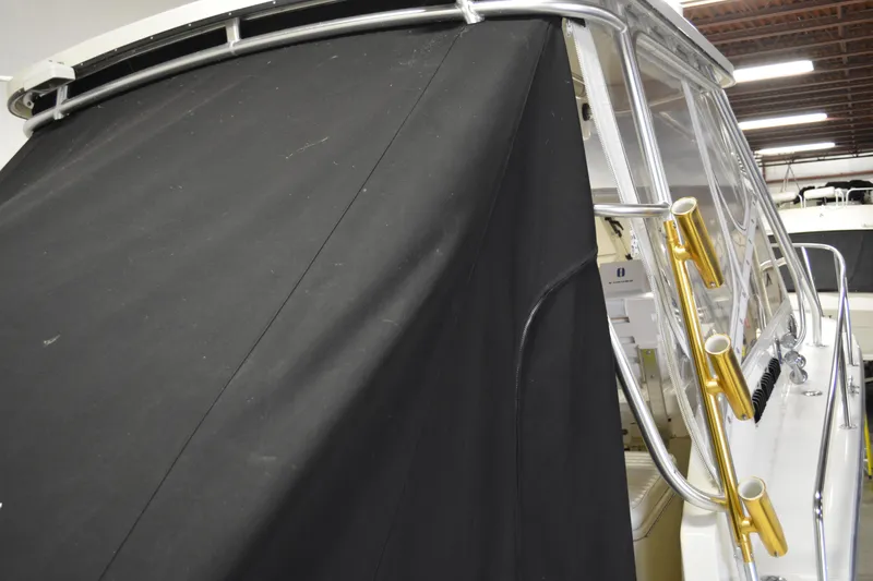 Slide: The Image of 2004 Carolina Classic 28 boat with black canvas cover and metal railings. - 8