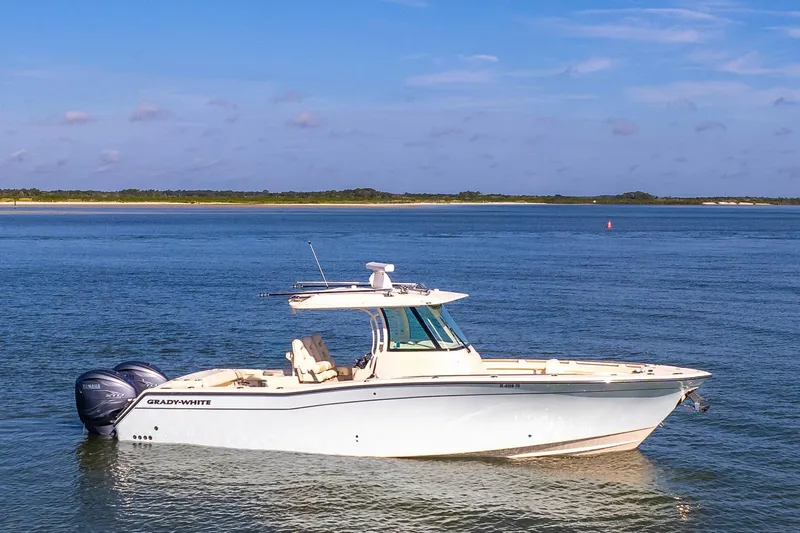 Slide: The Image of 2022 Grady-White Canyon 336 boat on calm water under blue sky. - 1