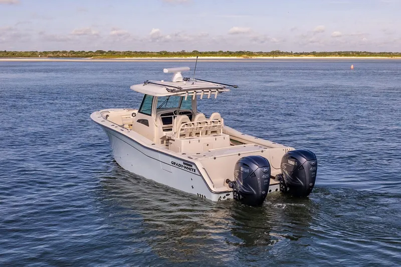 Slide: The Image of 2022 Grady-White Canyon 336 boat on open water, featuring dual outboard engines. - 10
