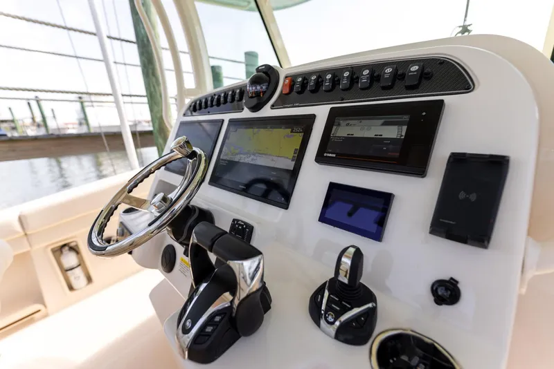 Slide: The Image of Control panel of 2022 Grady-White Canyon 336 boat with steering wheel and navigation screens. - 14