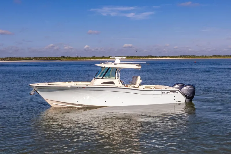 Slide: The Image of 2022 Grady-White Canyon 336 boat on calm water under blue sky. - 2