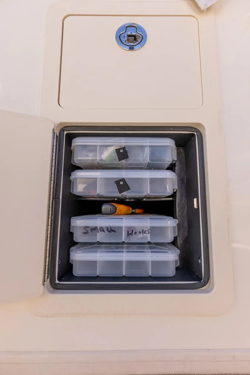 Slide: The Image of Storage compartment on 2022 Grady-White Canyon 336 boat with organized tackle boxes. - 26