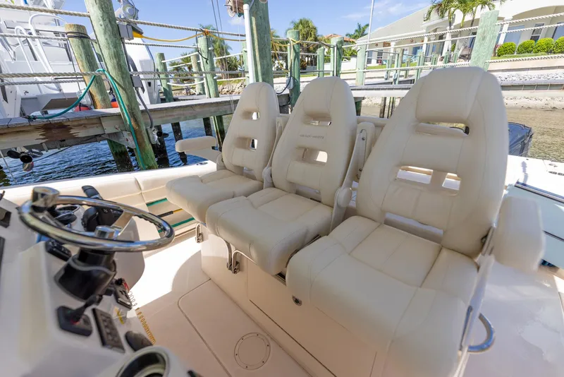 Slide: The Image of 2022 Grady-White Canyon 336 boat with luxurious helm seating at a marina. - 28