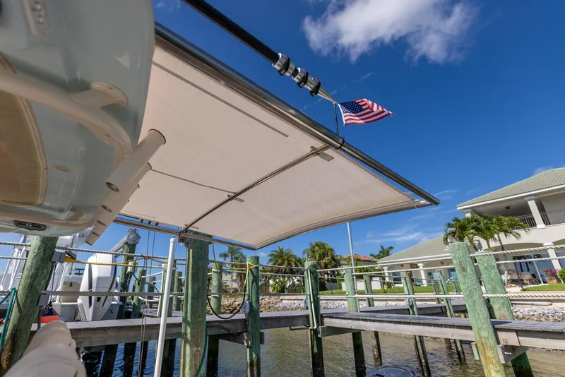 Slide: The Image of 2022 Grady-White Canyon 336 boat docked, featuring a sunshade and American flag. - 34