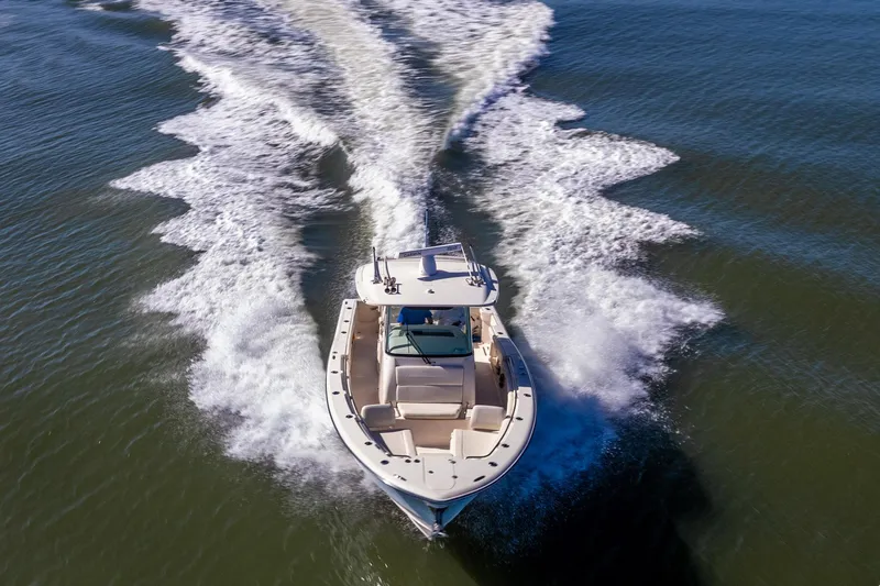 Slide: The Image of 2022 Grady-White Canyon 336 boat cruising on open water, creating dynamic wake patterns. - 4