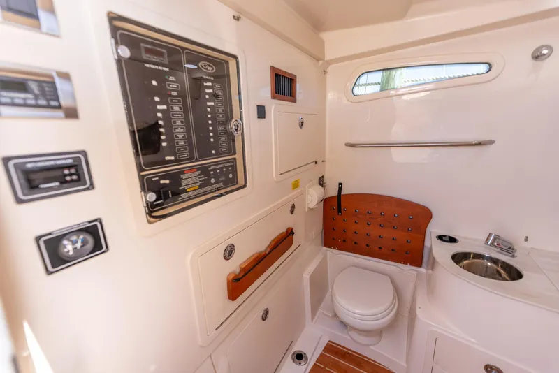 Slide: The Image of 2022 Grady-White Canyon 336 boat interior with control panel and compact bathroom. - 43
