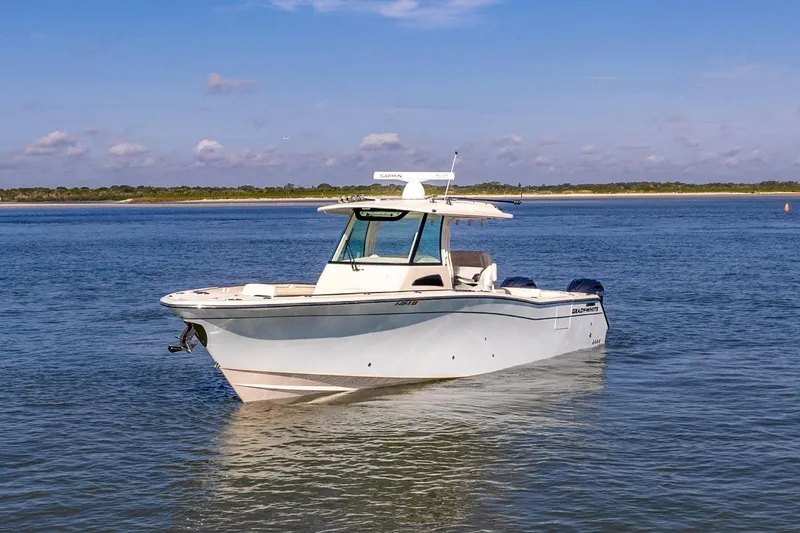 Slide: The Image of 2022 Grady-White Canyon 336 boat on calm water under blue sky. - 6