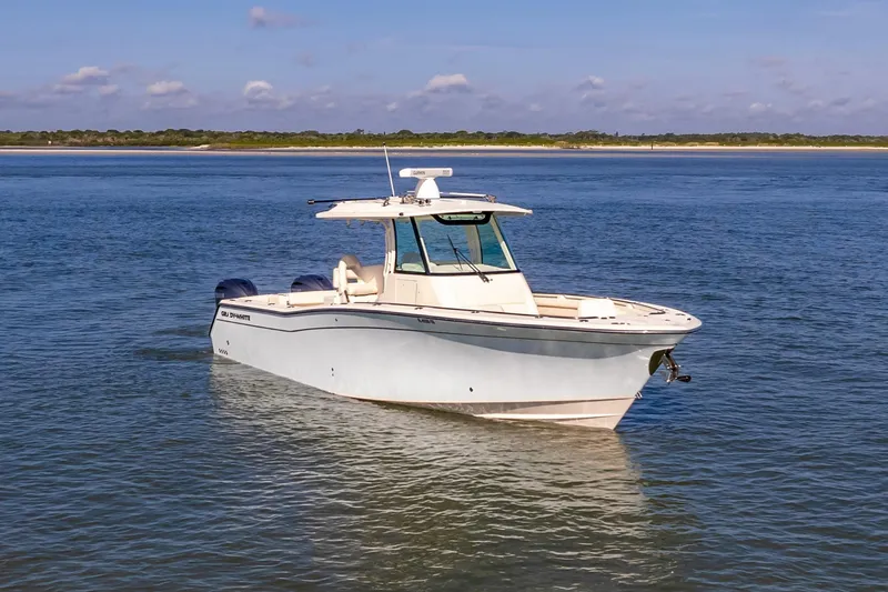 Slide: The Image of 2022 Grady-White Canyon 336 boat on calm water, clear sky background. - 7
