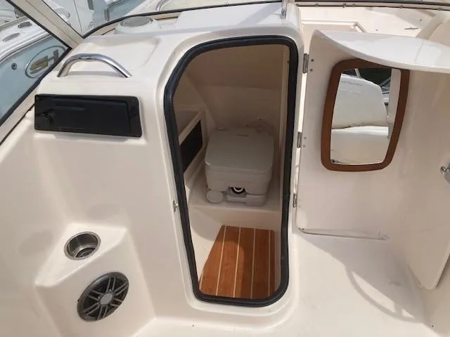 Slide: The Image of 2022 Grady-White Freedom 215 boat interior with compact toilet and wooden flooring. - 7