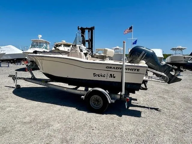 Slide: The Image of 2020 Grady-White Fisherman 180 boat on trailer, parked outdoors under clear blue sky. - 1
