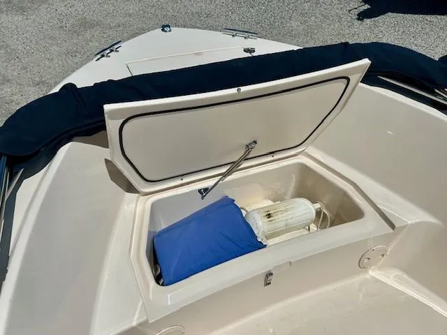 Slide: The Image of Open storage compartment on 2020 Grady-White Fisherman 180 boat, containing a blue cushion and fender. - 9