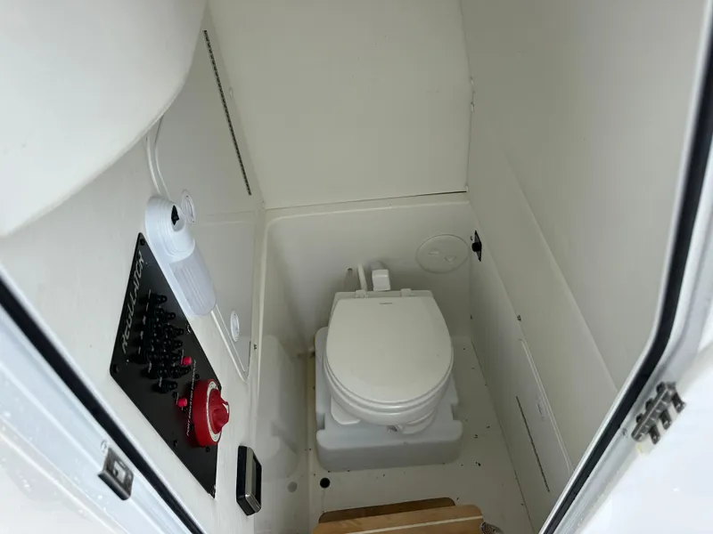Slide: The Image of 2020 Regulator 23 Forward Seating boat interior with toilet and control panel. - 10