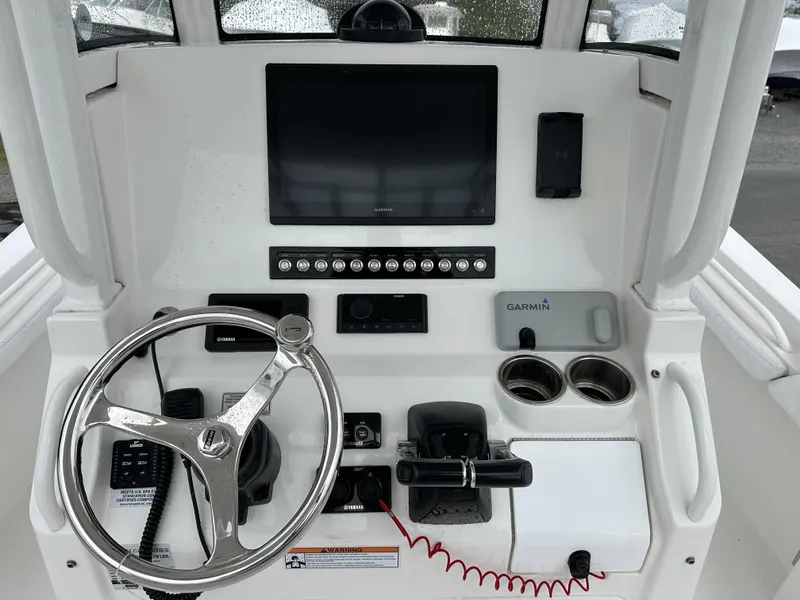 Slide: The Image of 2020 Regulator 23 Forward Seating boat console with steering wheel and electronic controls. - 2