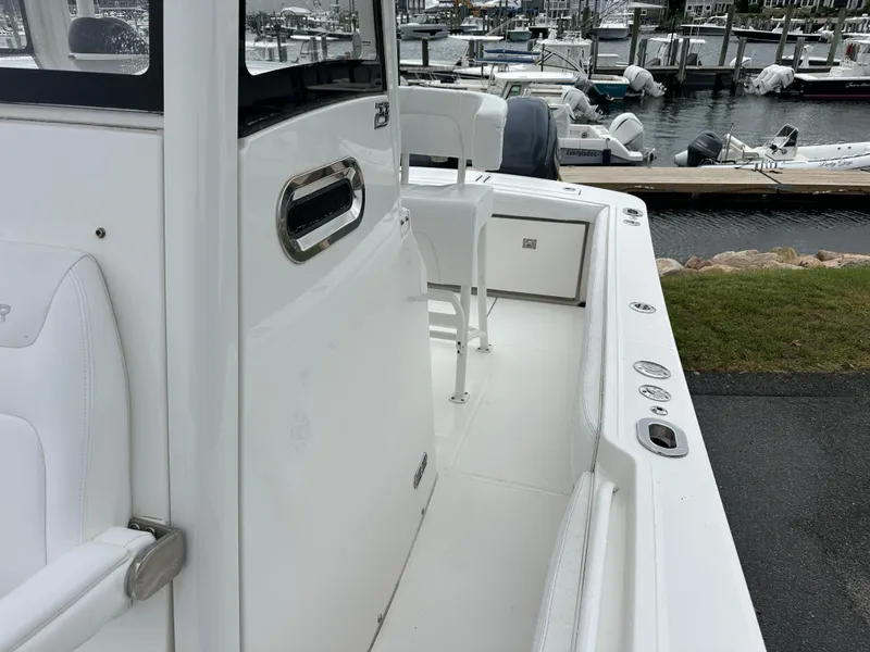Slide: The Image of 2020 Regulator 23 Forward Seating boat docked at a marina, showcasing sleek white design. - 6