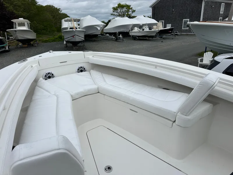 Slide: The Image of 2020 Regulator 23 Forward Seating boat with white cushioned seats, docked outdoors. - 7