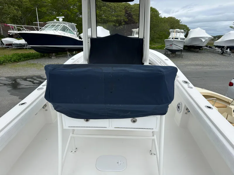 Slide: The Image of 2020 Regulator 23 Forward Seating boat with covered console, docked among other boats. - 9