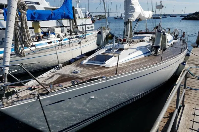 Slide: The Image of 1992 Nautor Swan 44 sailboat docked, showcasing sleek design and wooden deck. - 1